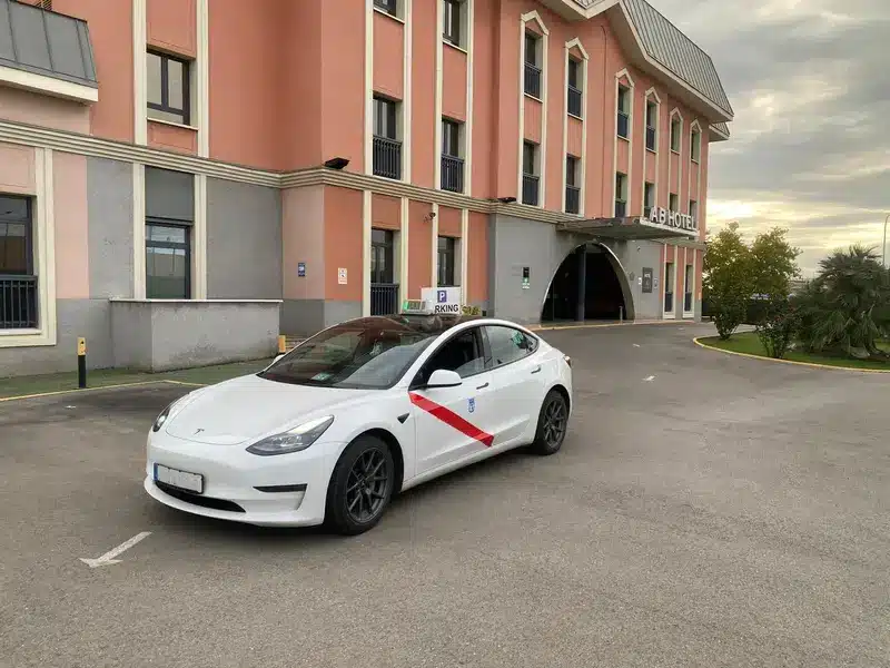 Taxi Van Premium Tesla Model 3 frente a AB Hotel